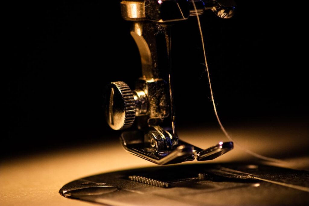 Detailed close-up image of a sewing machine with a threaded needle, perfect for textile and crafting themes.